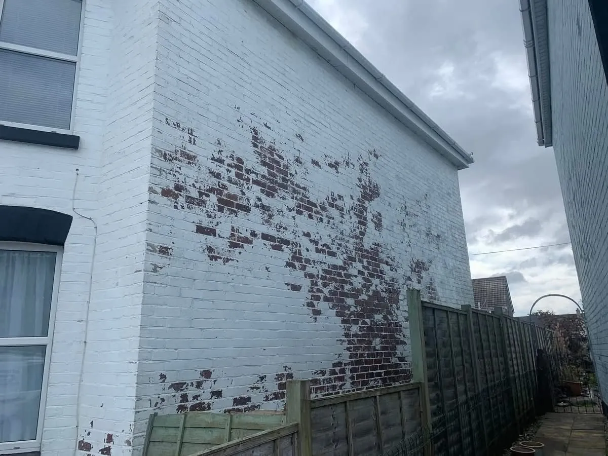 Peeling paint on a brick wall before redecoration in Boscastle